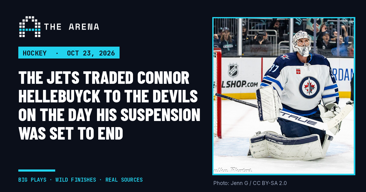 Connor Hellebuyck in a white Winnipeg Jets uniform, kneeling in his crease during a 2024 game